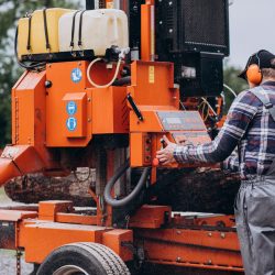 Carpenter working on a sawmill on a wood manufacture
